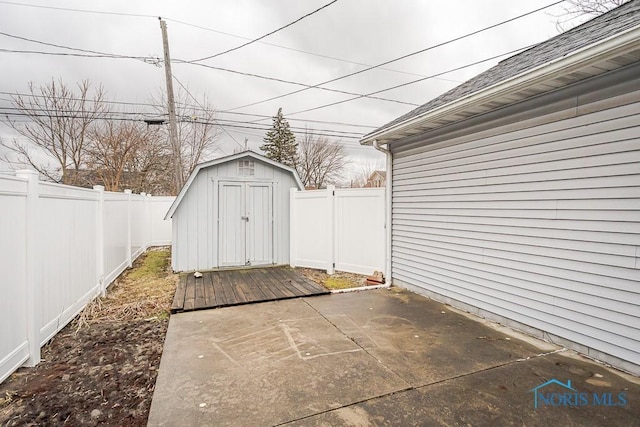 view of patio with a fenced backyard, a storage unit, and an outbuilding