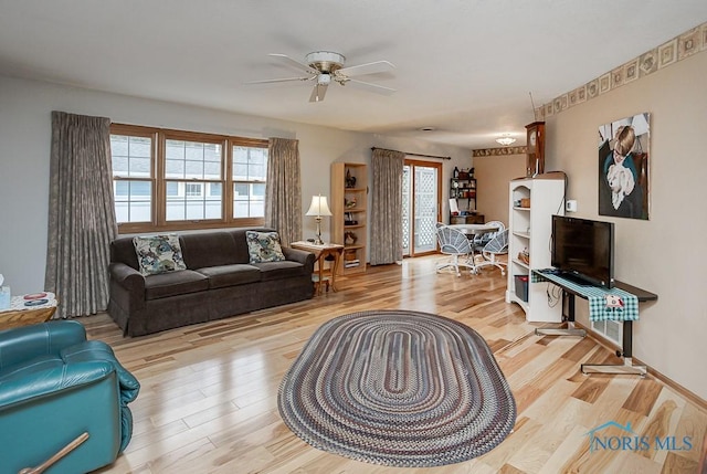 living room featuring a ceiling fan and wood finished floors