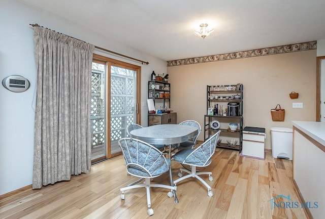 dining area with light wood-type flooring and baseboards