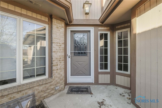 view of exterior entry with brick siding