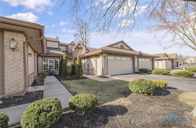 view of front of house featuring a garage, brick siding, and driveway