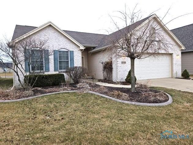 single story home with a garage, a front yard, brick siding, and driveway