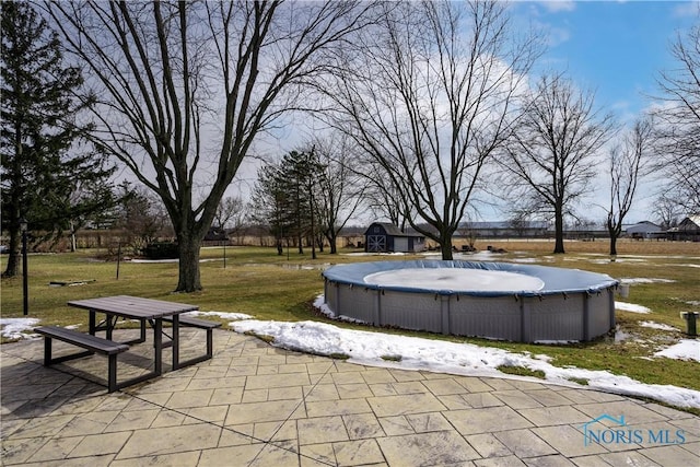 view of property's community featuring a yard, a patio area, and a pool