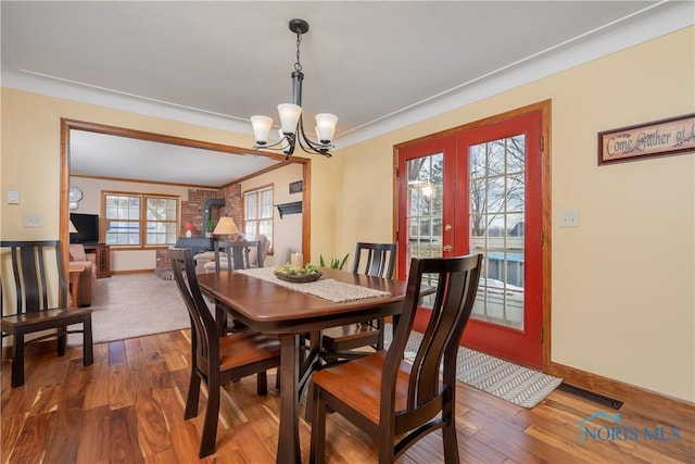 dining area featuring baseboards, visible vents, wood finished floors, and french doors