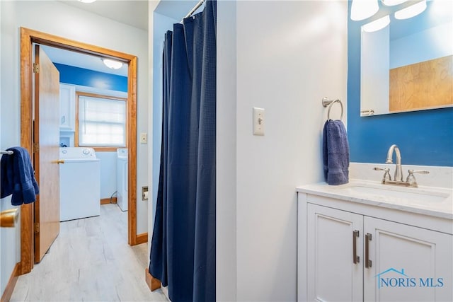 full bathroom featuring vanity, washing machine and clothes dryer, and wood finished floors