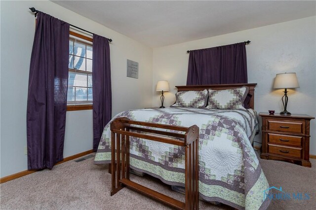 carpeted bedroom with visible vents and baseboards