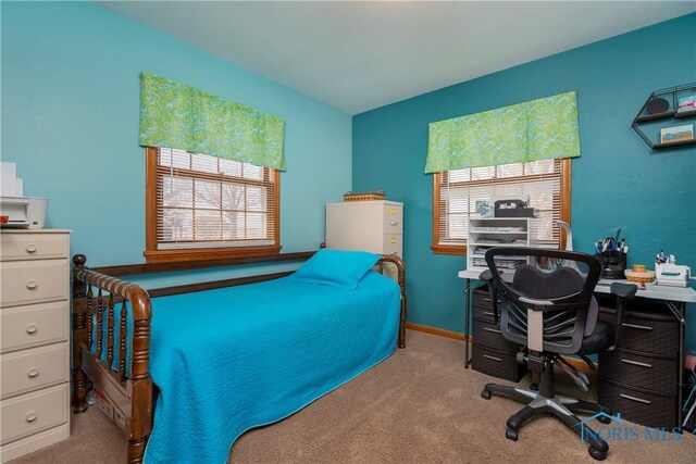 carpeted bedroom featuring multiple windows and baseboards