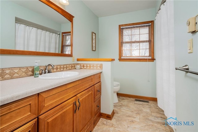 full bath with visible vents, a shower with shower curtain, toilet, vanity, and baseboards