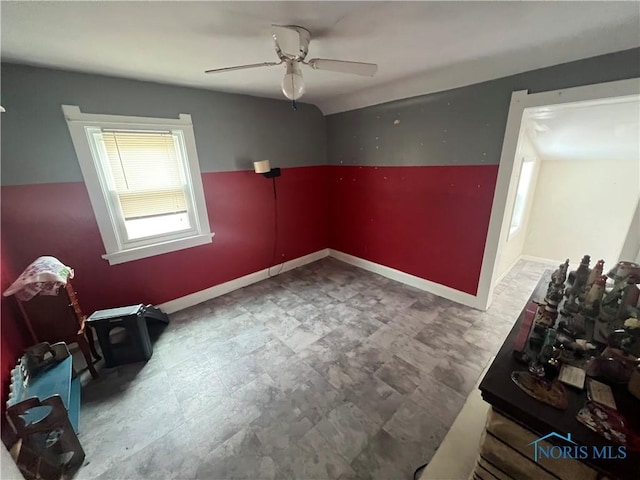 spare room featuring ceiling fan and baseboards