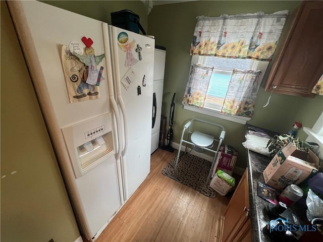 kitchen featuring fridge, light wood-style flooring, and white refrigerator with ice dispenser