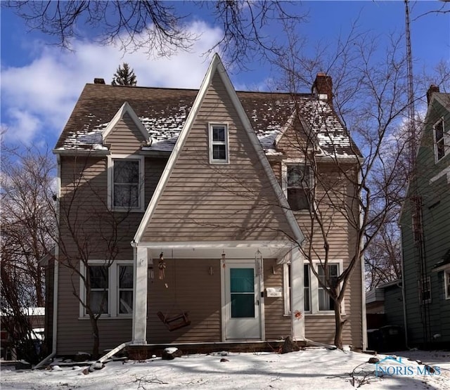 view of front facade with covered porch and a chimney