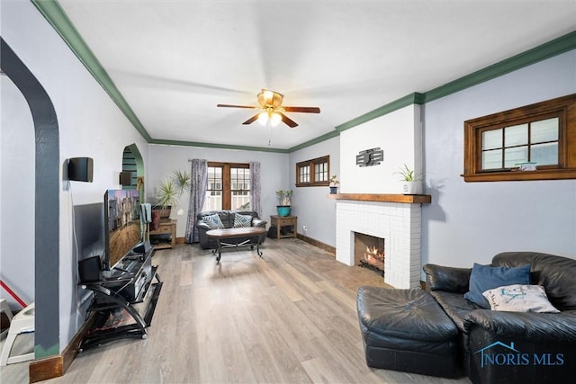 4526 Eastway St, Toledo, OH 43612 - living room with ornamental molding, arched walkways, light wood-style floors, baseboards, and a brick fireplace