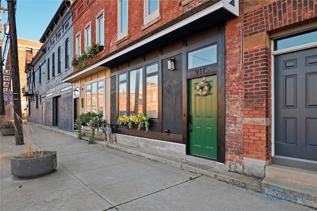 view of exterior entry featuring brick siding