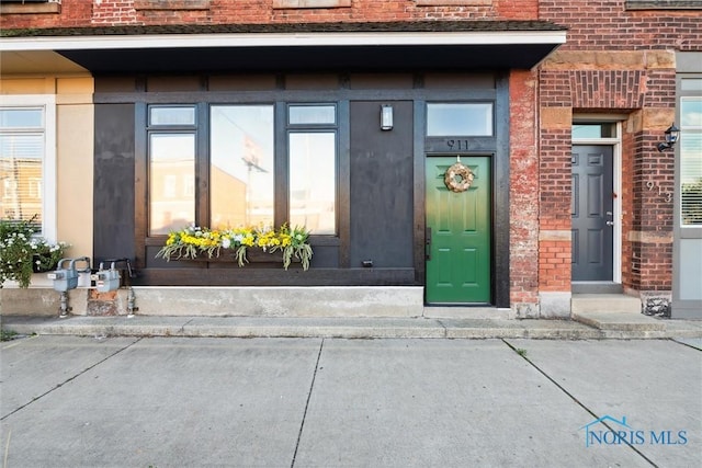 view of exterior entry featuring brick siding