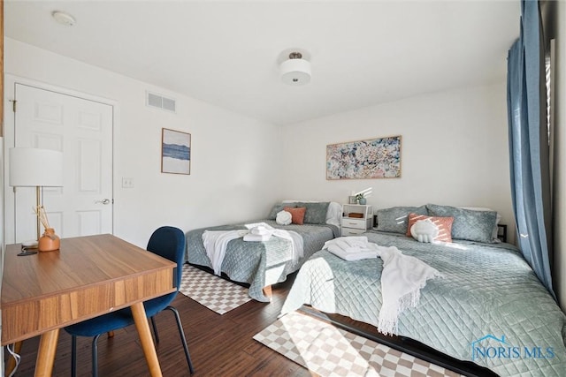 bedroom featuring visible vents and wood finished floors