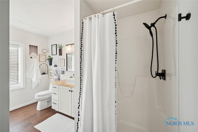 bathroom with a shower with curtain, vanity, toilet, and wood finished floors