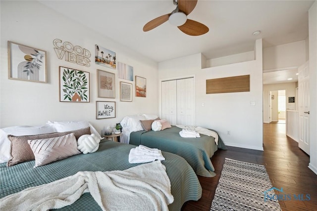 bedroom with ceiling fan, a closet, wood finished floors, and baseboards