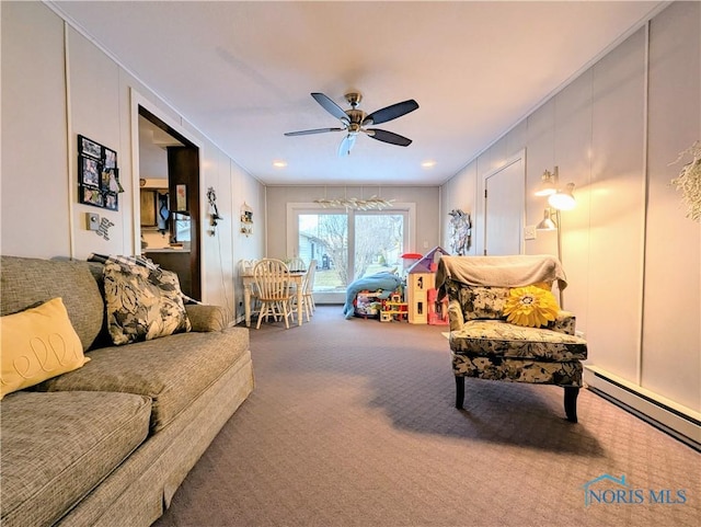 carpeted living area featuring a baseboard heating unit, a decorative wall, and a ceiling fan