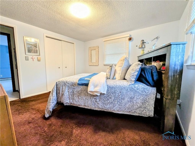 bedroom with carpet, a closet, a textured ceiling, and baseboards