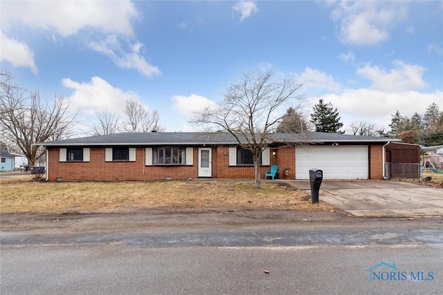 ranch-style home featuring a garage, concrete driveway, and brick siding