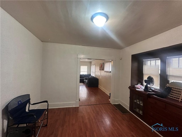 hall with baseboards and dark wood-style flooring