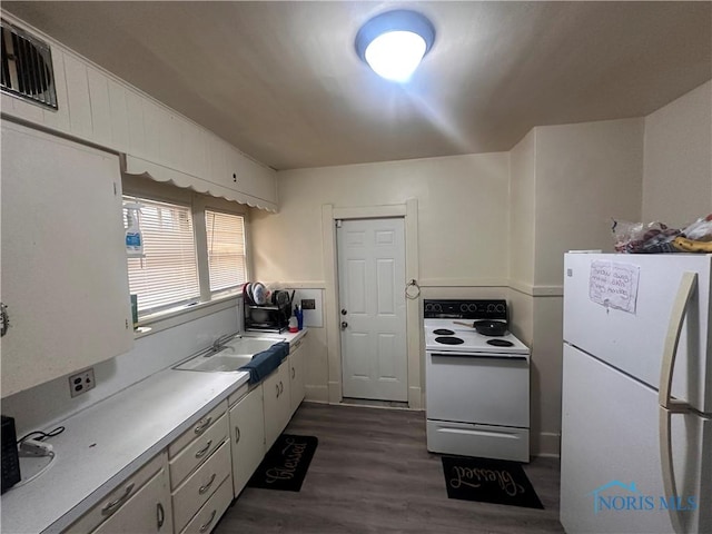 kitchen featuring white appliances, a sink, visible vents, white cabinets, and dark wood-style floors