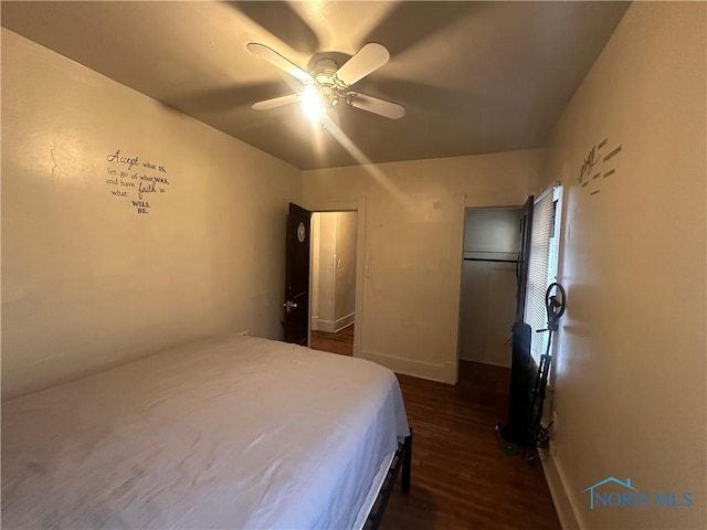 bedroom with a ceiling fan, dark wood finished floors, and baseboards