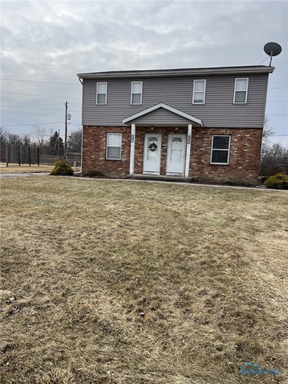 view of front of home featuring a front yard and brick siding