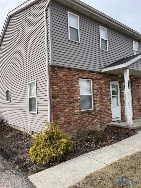 view of side of home featuring brick siding