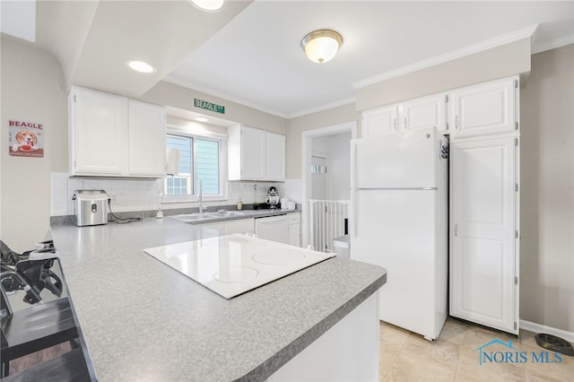 kitchen featuring a peninsula, white appliances, white cabinetry, and backsplash