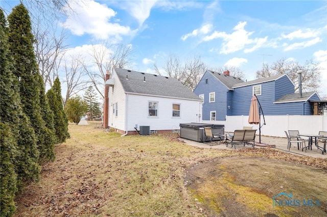 back of property featuring a patio, a chimney, a hot tub, central AC, and fence