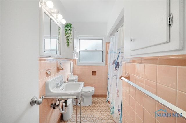 full bathroom featuring toilet, a sink, tile walls, and a shower with shower curtain