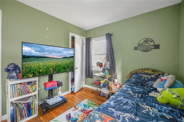 bedroom with baseboards and wood finished floors