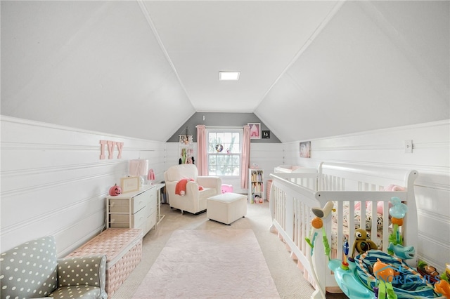 carpeted bedroom with a nursery area and lofted ceiling