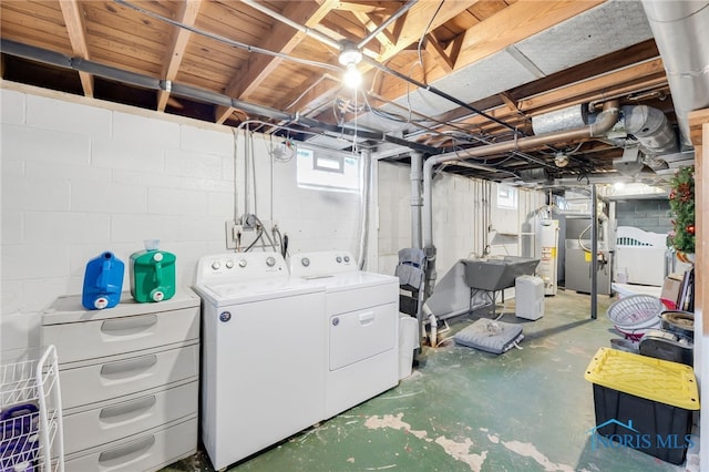 basement featuring water heater, separate washer and dryer, and a sink