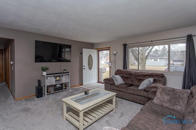 living area with a textured ceiling, carpet flooring, and baseboards