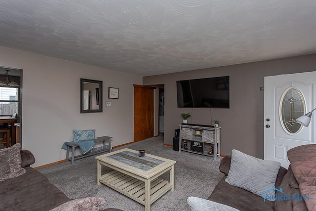 carpeted living area featuring baseboards and a textured ceiling