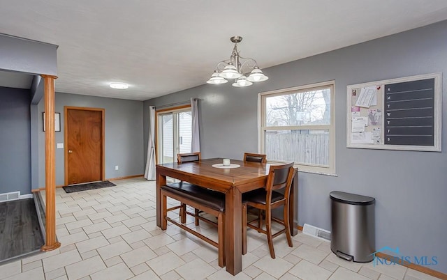 dining space with a chandelier, visible vents, and baseboards