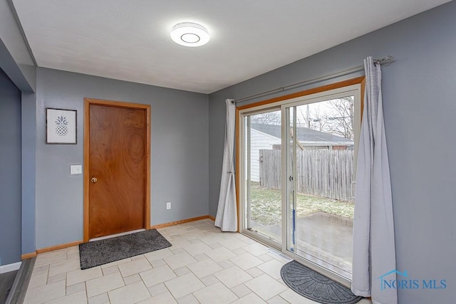 doorway to outside featuring baseboards