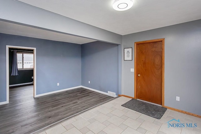 foyer with visible vents, baseboards, and wood finished floors