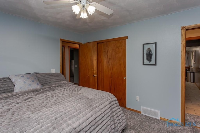 carpeted bedroom featuring baseboards, visible vents, ceiling fan, and a closet