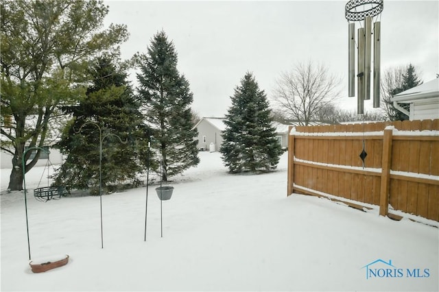 snowy yard with fence