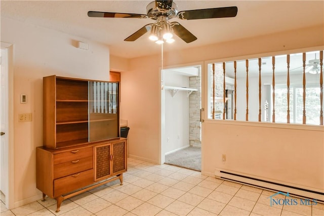 interior space with a baseboard radiator, a ceiling fan, and baseboards