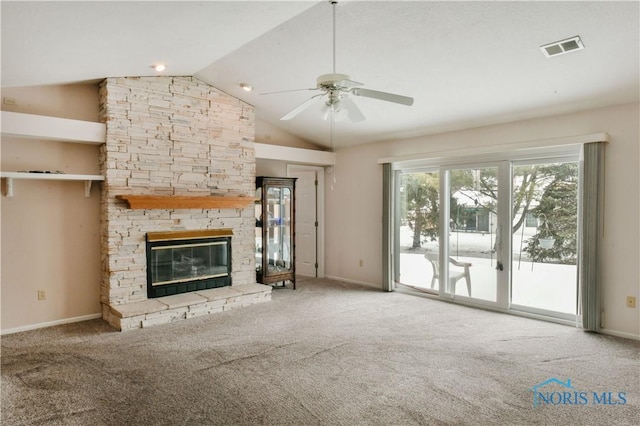 unfurnished living room with ceiling fan, a stone fireplace, carpet, and visible vents