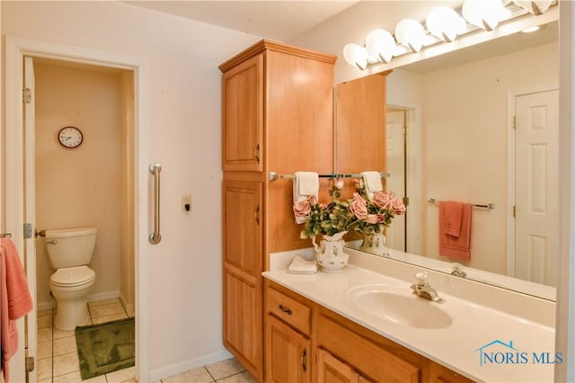 bathroom featuring vanity, tile patterned flooring, toilet, and baseboards