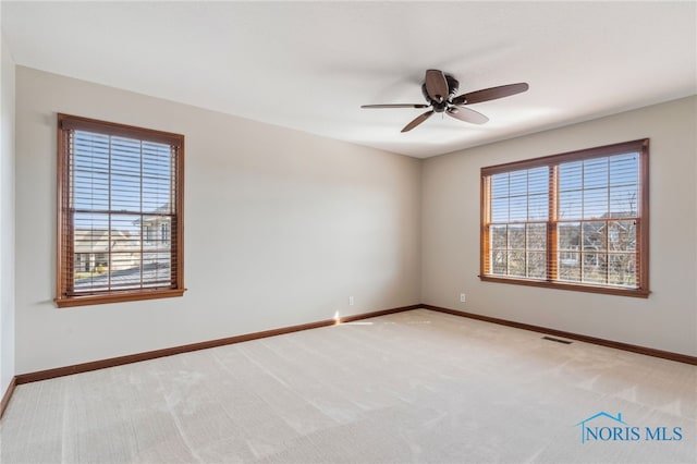 empty room with baseboards, carpet floors, visible vents, and a healthy amount of sunlight