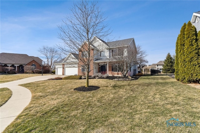 view of front facade with concrete driveway, brick siding, a front yard, and fence