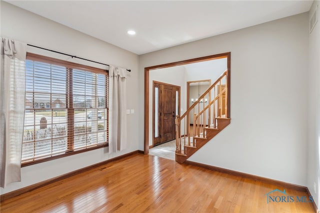 foyer entrance featuring visible vents, baseboards, stairway, hardwood / wood-style floors, and recessed lighting