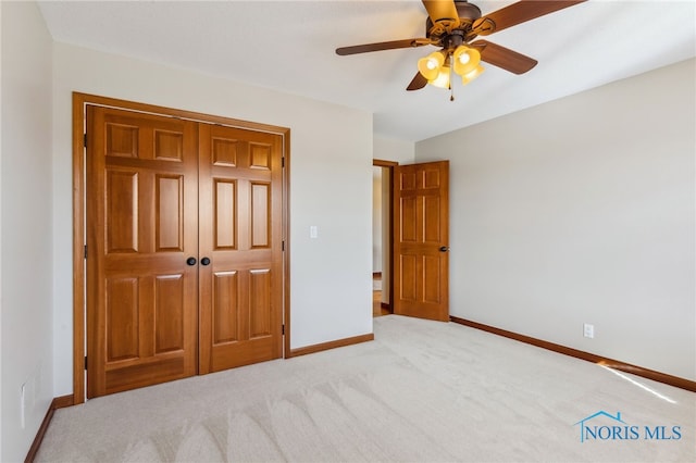 unfurnished bedroom with baseboards, visible vents, a ceiling fan, carpet, and a closet