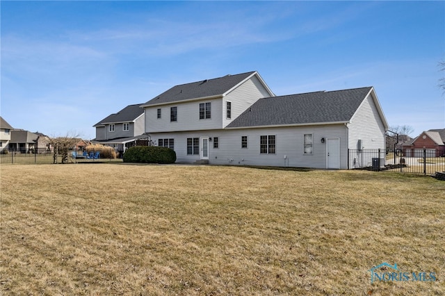 rear view of property featuring central AC unit, a lawn, and fence